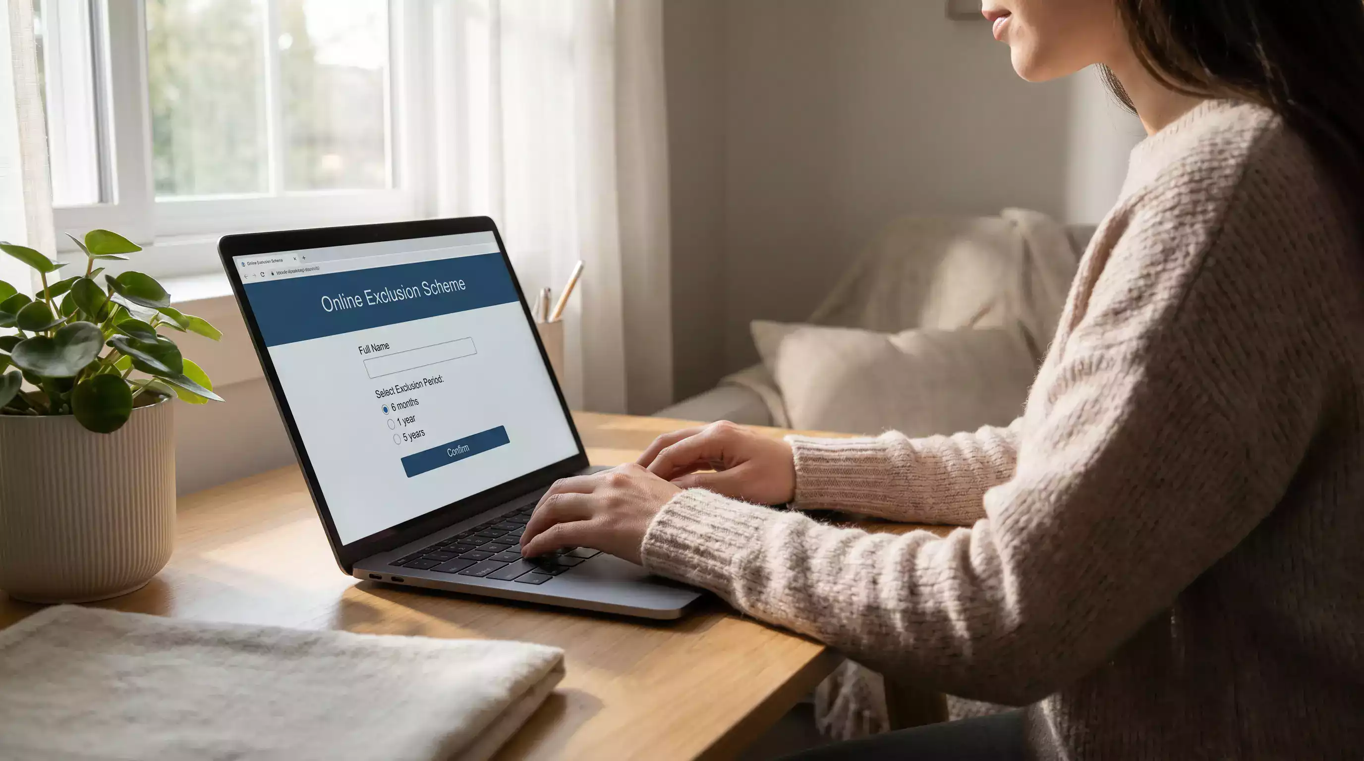 Person registering on a self-exclusion scheme website on a laptop with responsible gambling information on screen