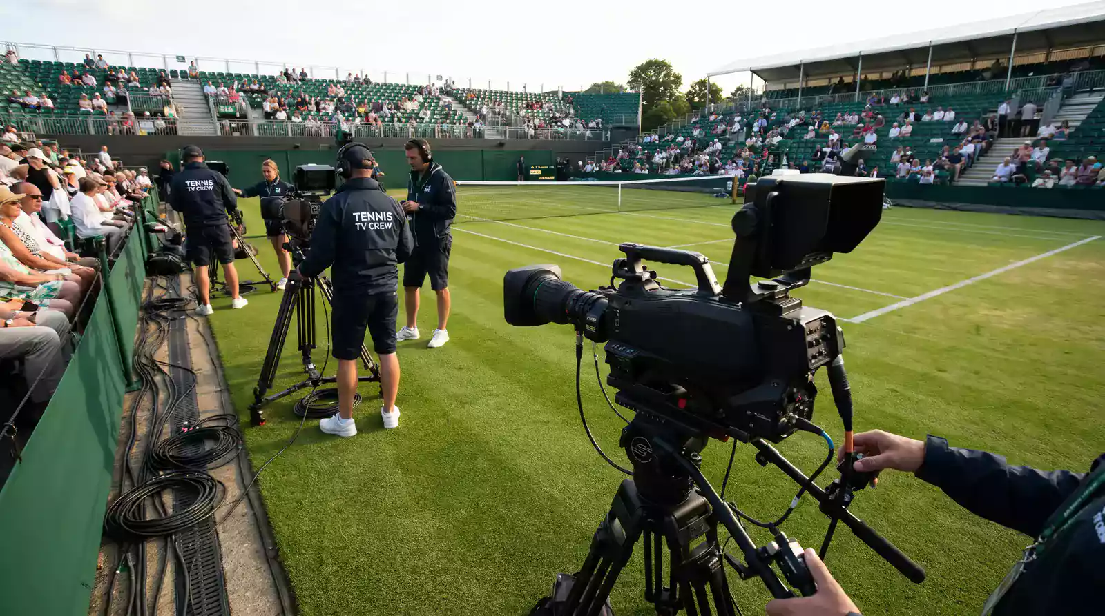 BBC broadcast crew setting up cameras courtside at Wimbledon for live television coverage
